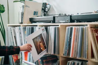 Uma pessoa escolhe um disco de vinil da sua coleção