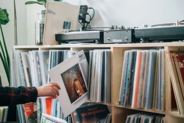 Uma pessoa escolhe um disco de vinil da sua coleção